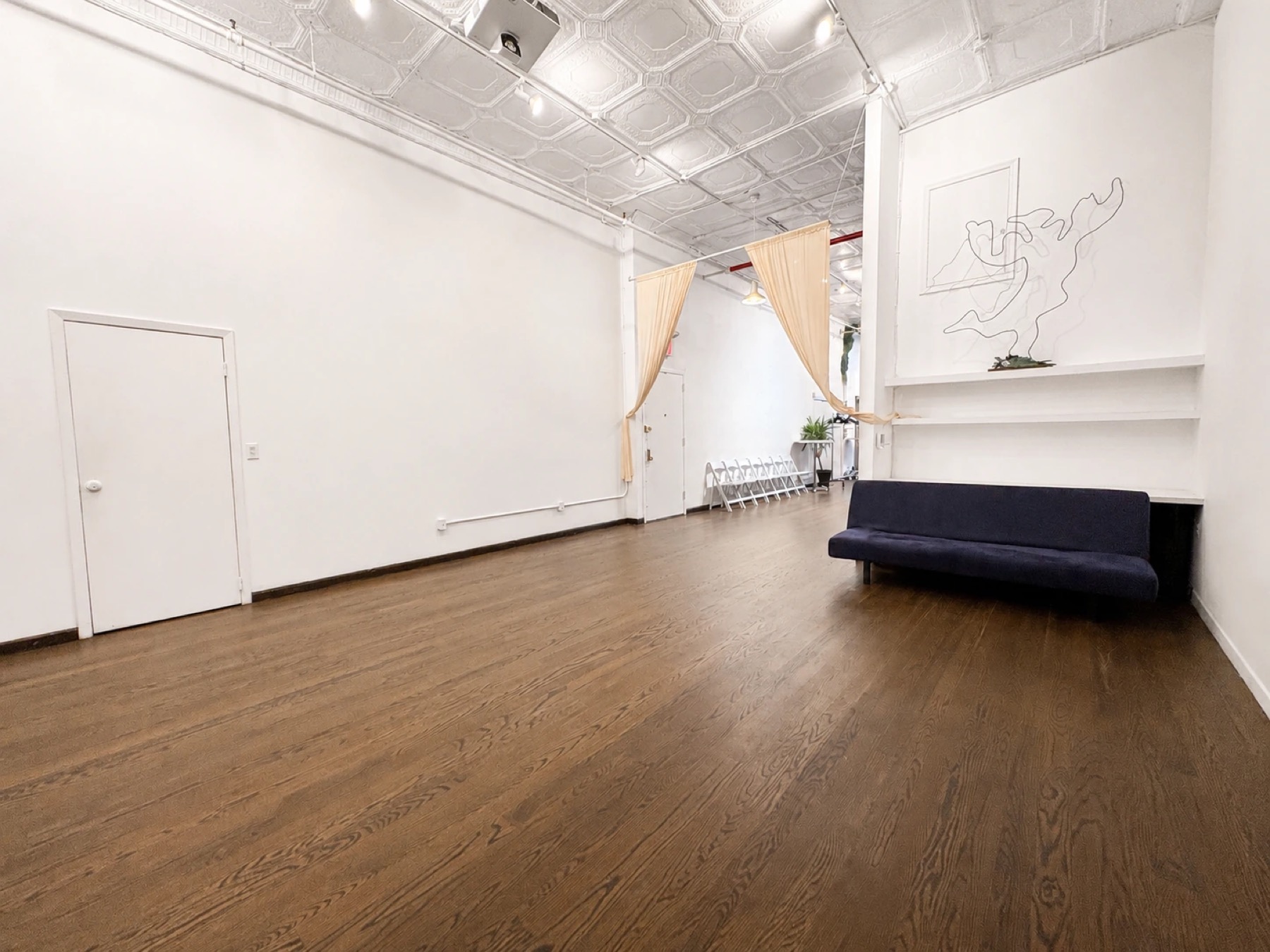 Open white-walled loft with dark hardwood floors